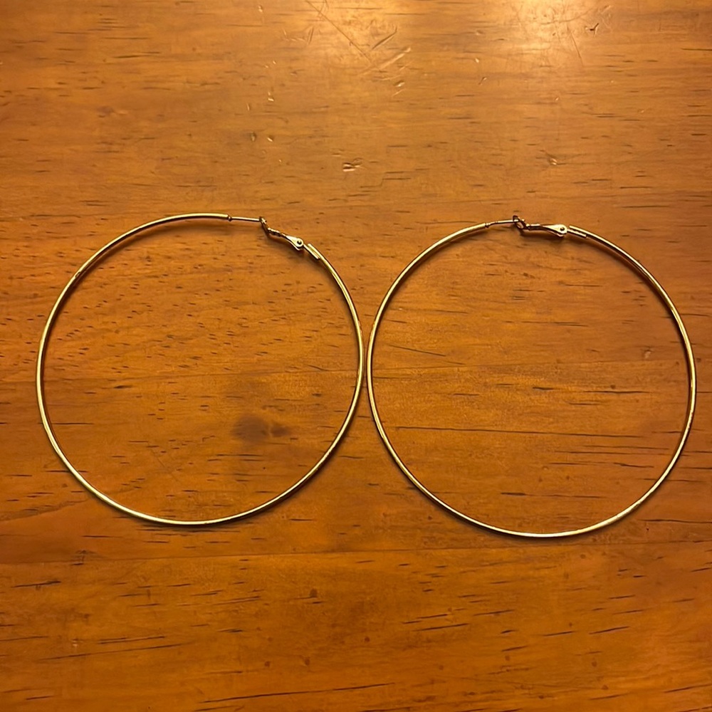 Rose gold color large hoop earrings.